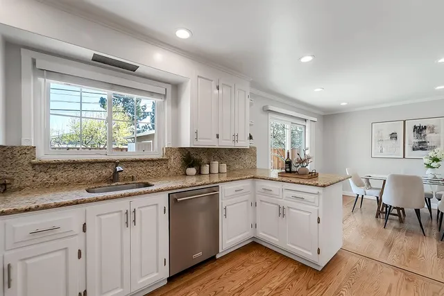 a kitchen with a sink white cabinets and white appliances