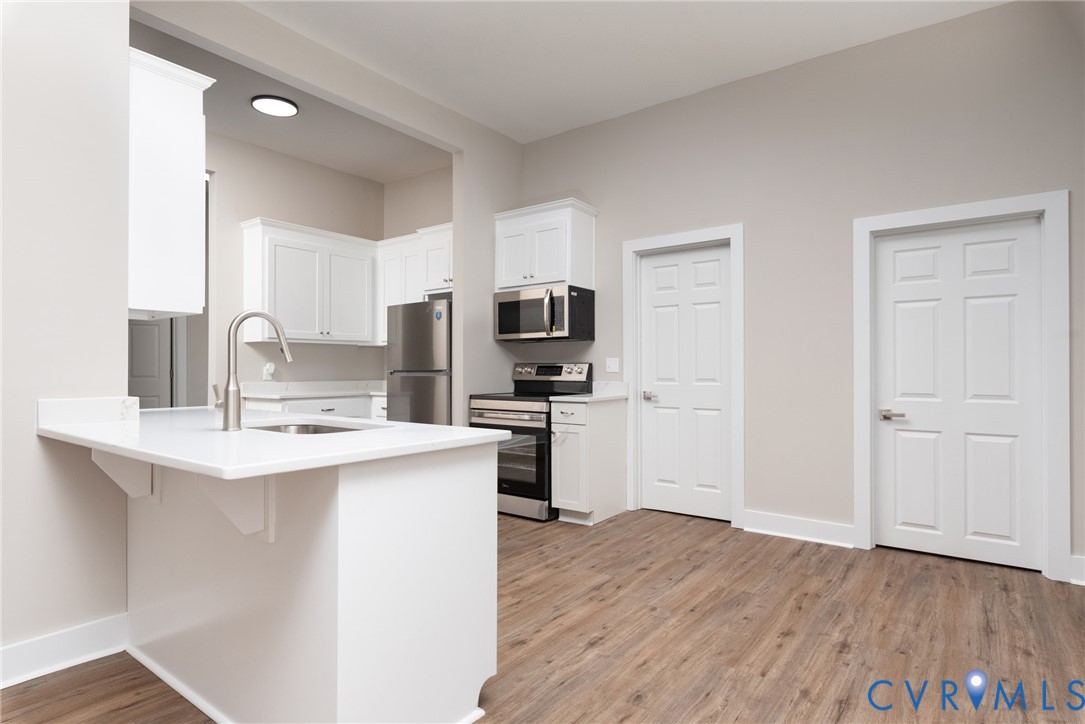 9800 Golf Course Drive Disputanta, VA 23842 - Photo 5 of 19 a kitchen with a sink a microwave a refrigerator and cabinets