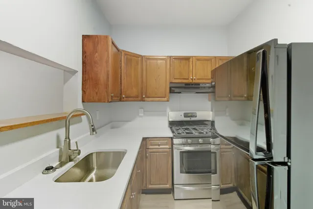 a kitchen with a refrigerator sink and cabinets