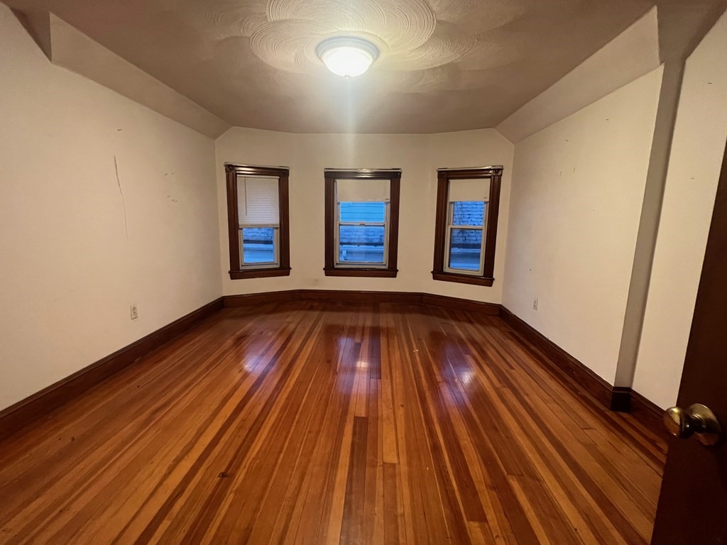 178 Larch Road Cambridge, MA 02138 - Photo 14 of 15 a view of an empty room with wooden floor and window