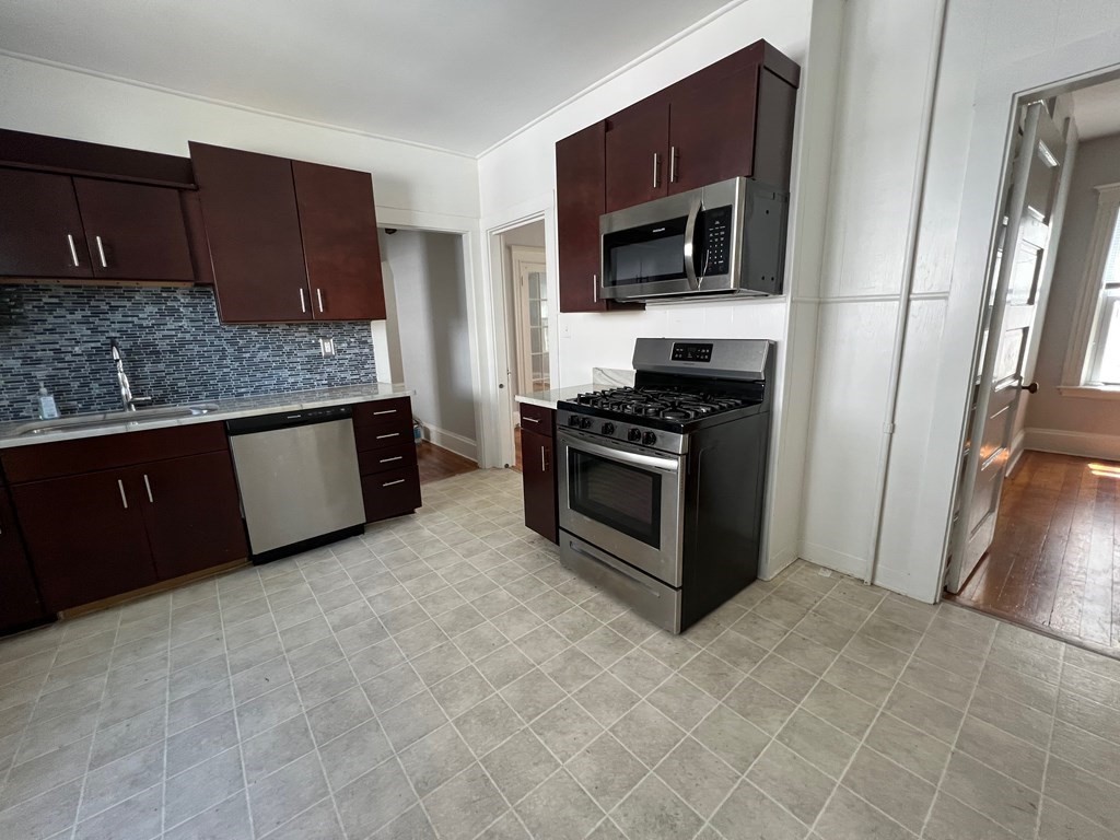 178 Larch Road Cambridge, MA 02138 - Photo 4 of 15 a kitchen with stainless steel appliances granite countertop a stove a microwave and a sink