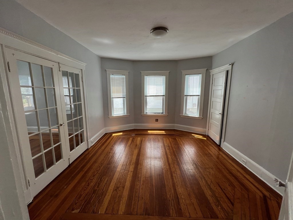 178 Larch Road Cambridge, MA 02138 - Photo 6 of 15 a view of an empty room with wooden floor and a window