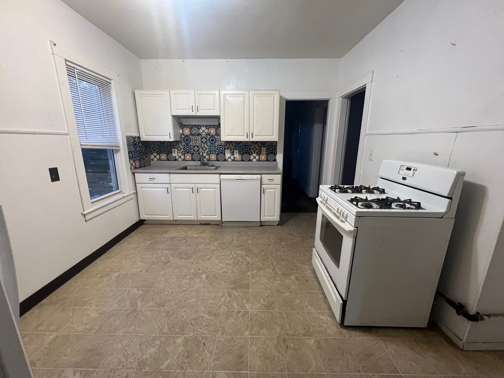 178 Larch Road Cambridge, MA 02138 - Photo 9 of 15 a kitchen with stainless steel appliances a refrigerator sink and stove