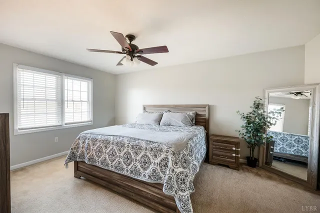 a bedroom with a bed a flat tv screen and a dresser
