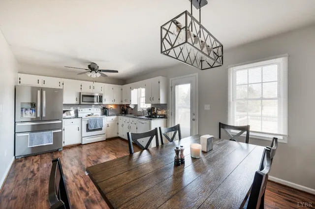 a kitchen with granite countertop white cabinets and white stainless steel appliances