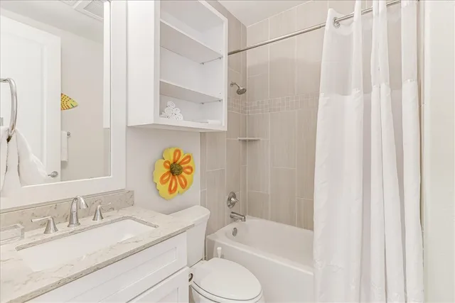 a bathroom with a granite countertop toilet sink and mirror