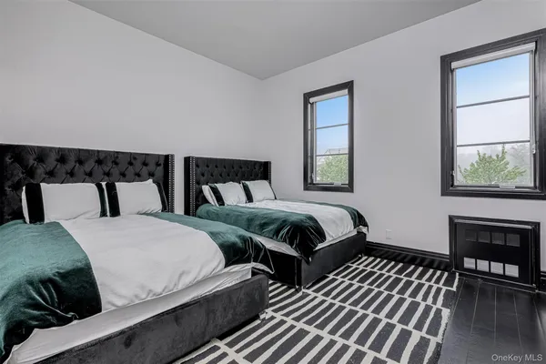 a bedroom with two beds and painting on the wall