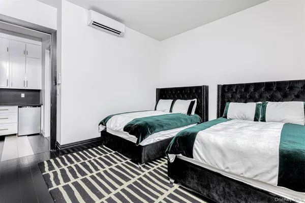 a bedroom with two beds and a wooden floor