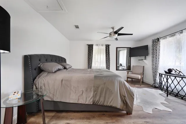 a spacious bedroom with a bed a couch and a flat screen tv