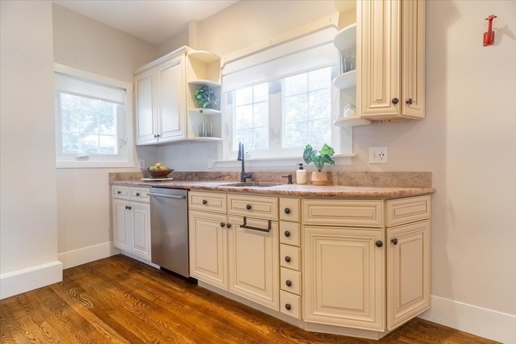 132 Church Street, Unit 1 Waltham, MA 02452 - Photo 11 of 42 a kitchen with granite countertop white cabinets white appliances and sink