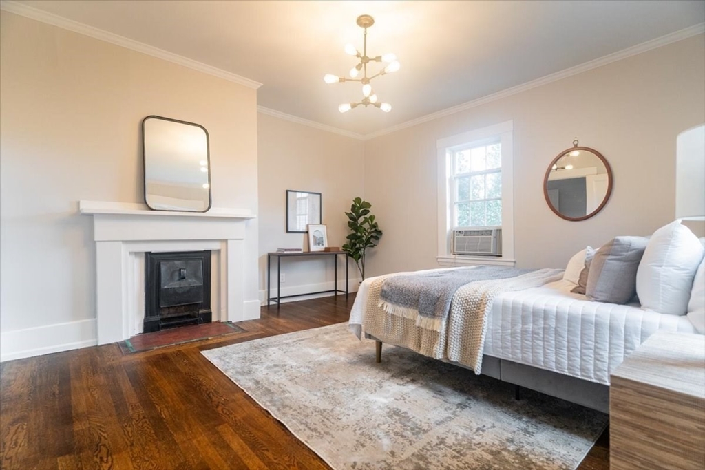 132 Church Street, Unit 1 Waltham, MA 02452 - Photo 17 of 42 a bedroom with a bed and a fireplace