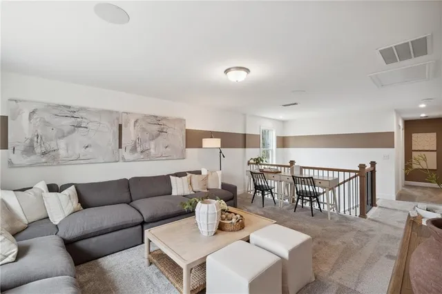 a living room with furniture and kitchen view
