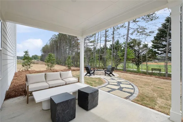 a living room with patio furniture and a garden