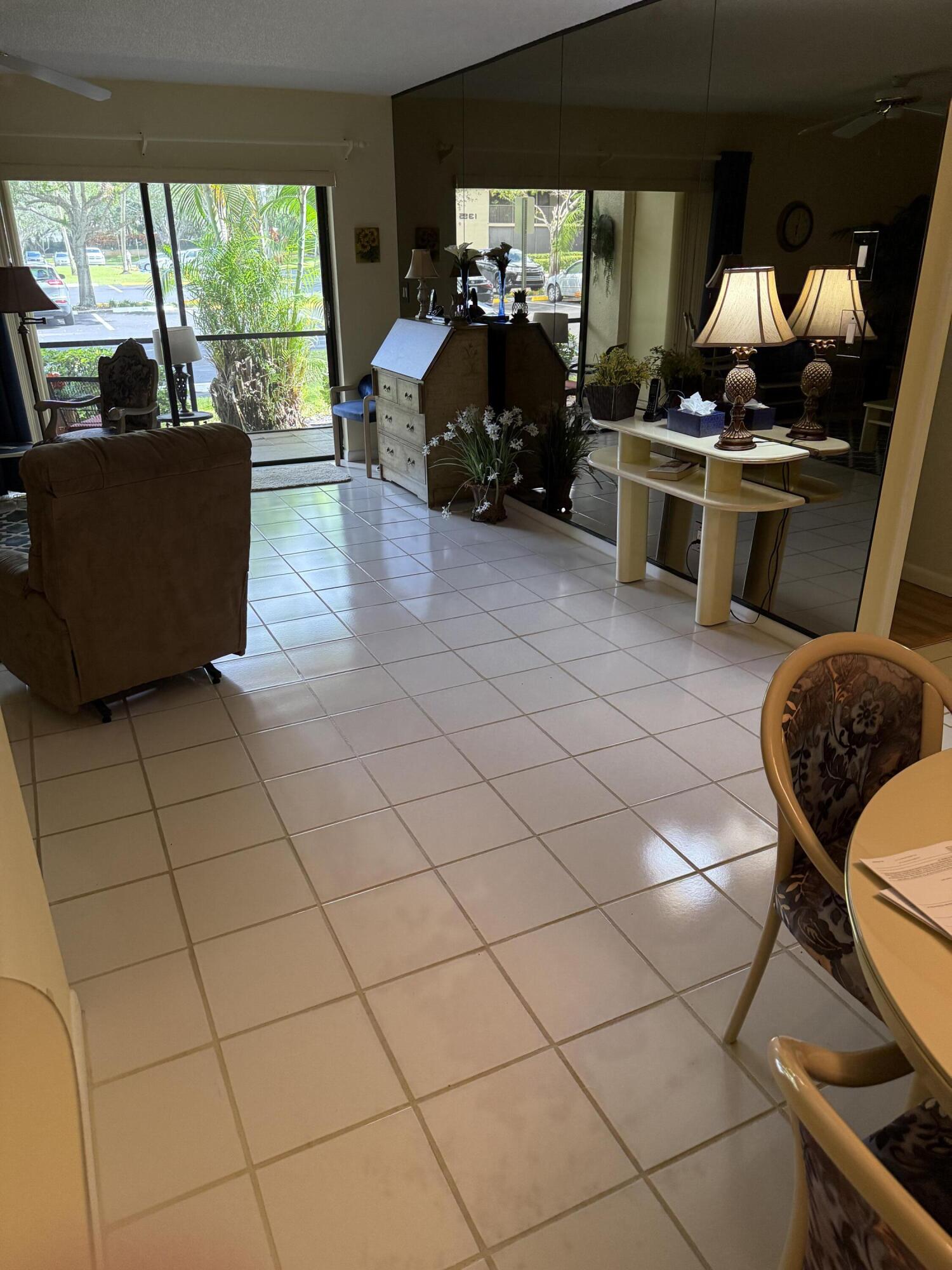 147 Deer Creek Boulevard, Unit 402 Deerfield Beach, FL 33442 - Photo 12 of 81 a living room with patio furniture and a large window