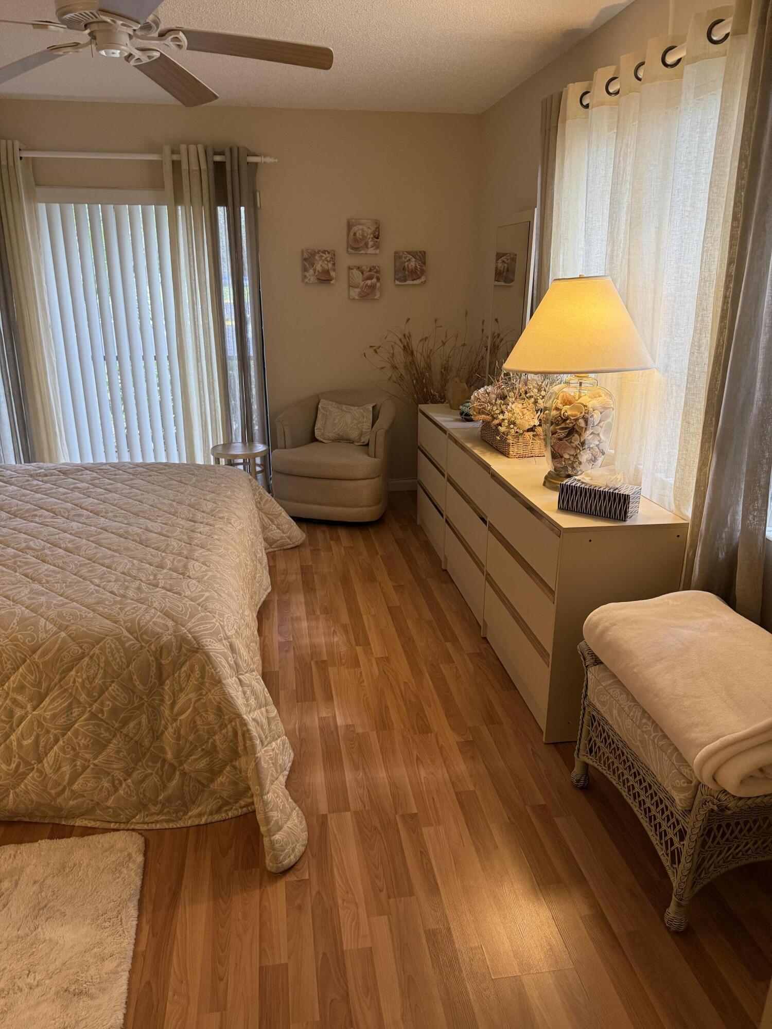 147 Deer Creek Boulevard, Unit 402 Deerfield Beach, FL 33442 - Photo 42 of 81 a bedroom with a bed and a chandelier