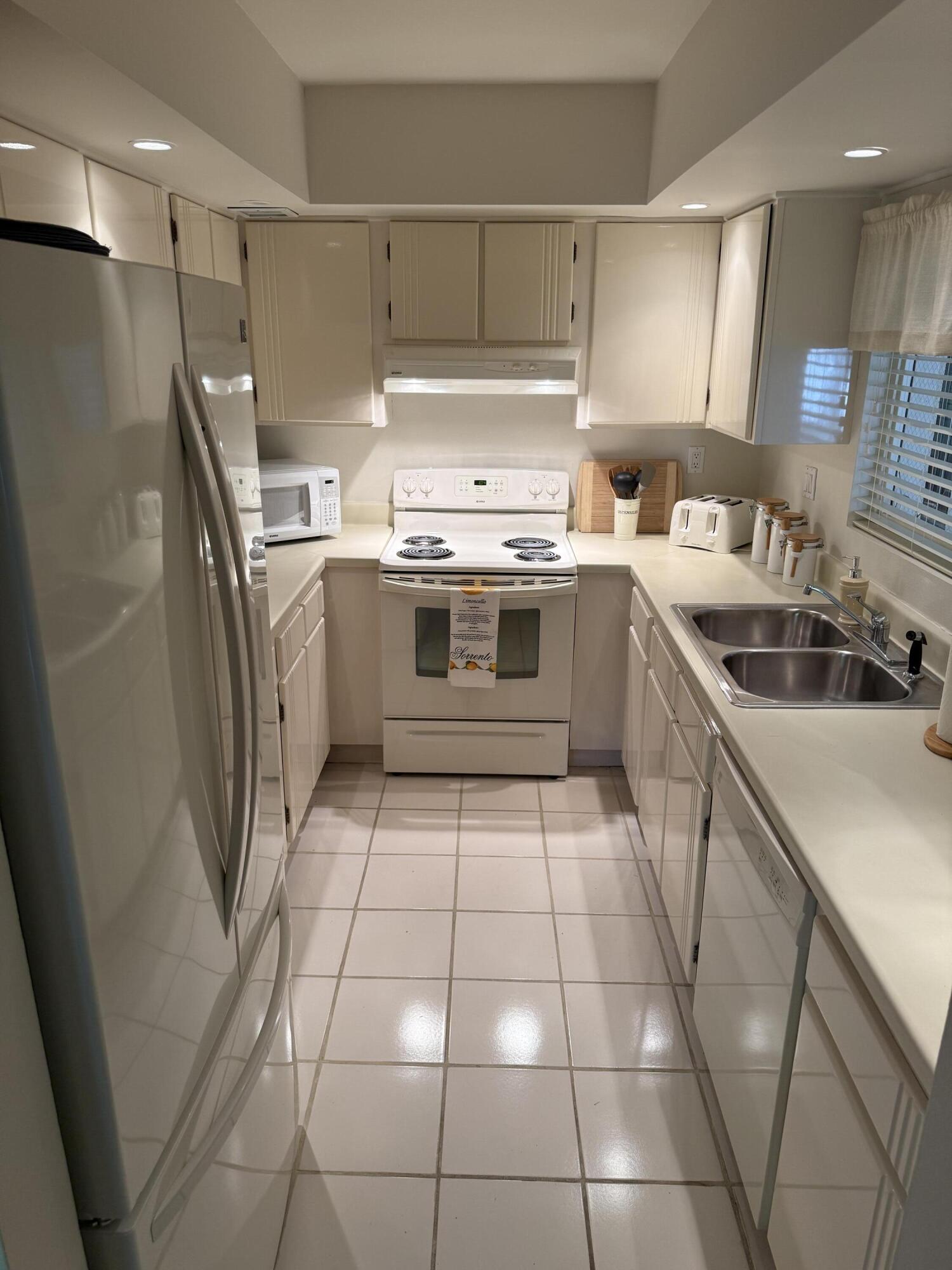 147 Deer Creek Boulevard, Unit 402 Deerfield Beach, FL 33442 - Photo 5 of 81 a kitchen with a stove a sink and a refrigerator