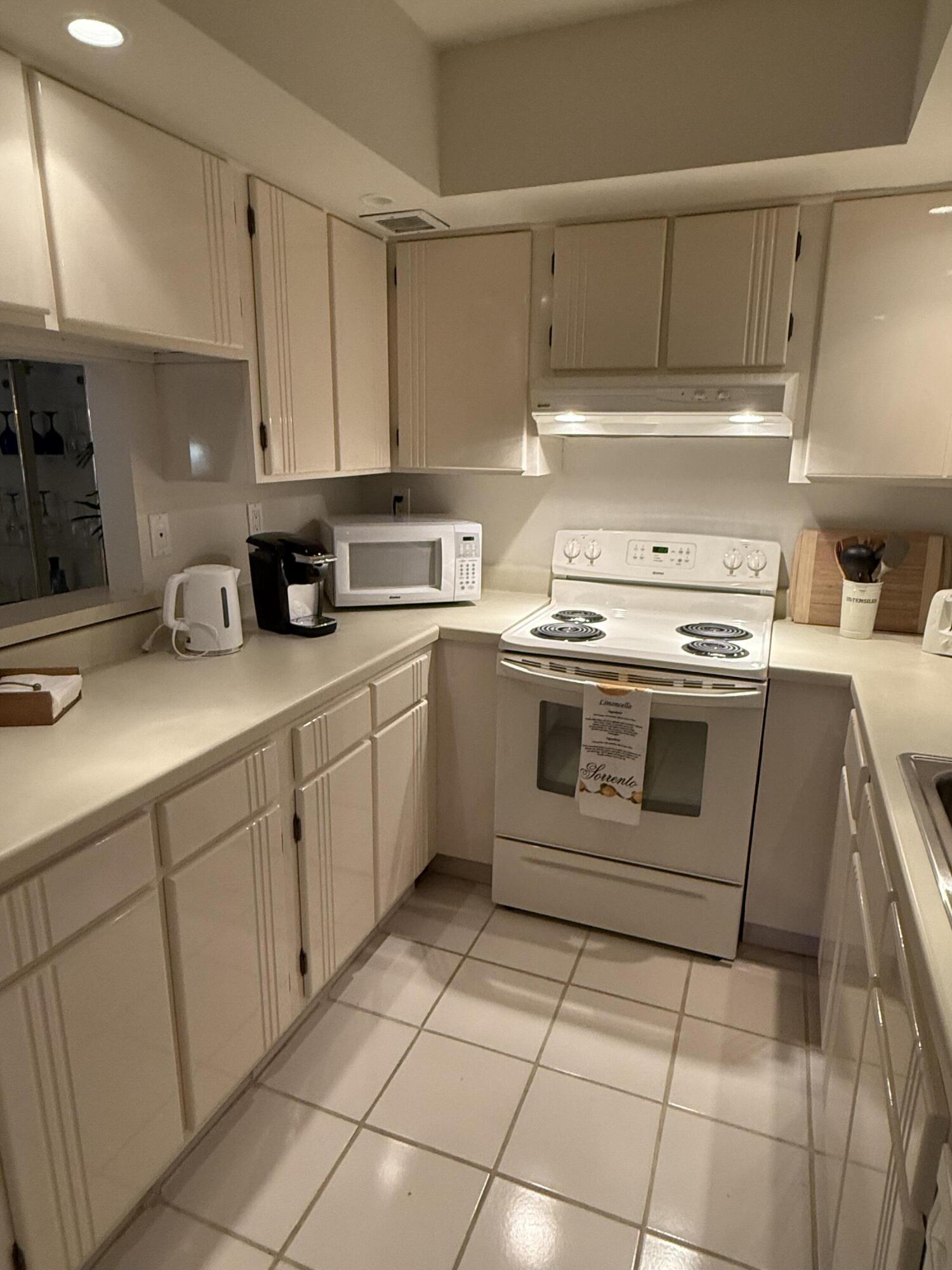 147 Deer Creek Boulevard, Unit 402 Deerfield Beach, FL 33442 - Photo 6 of 81 a kitchen with a stove top oven sink and cabinets