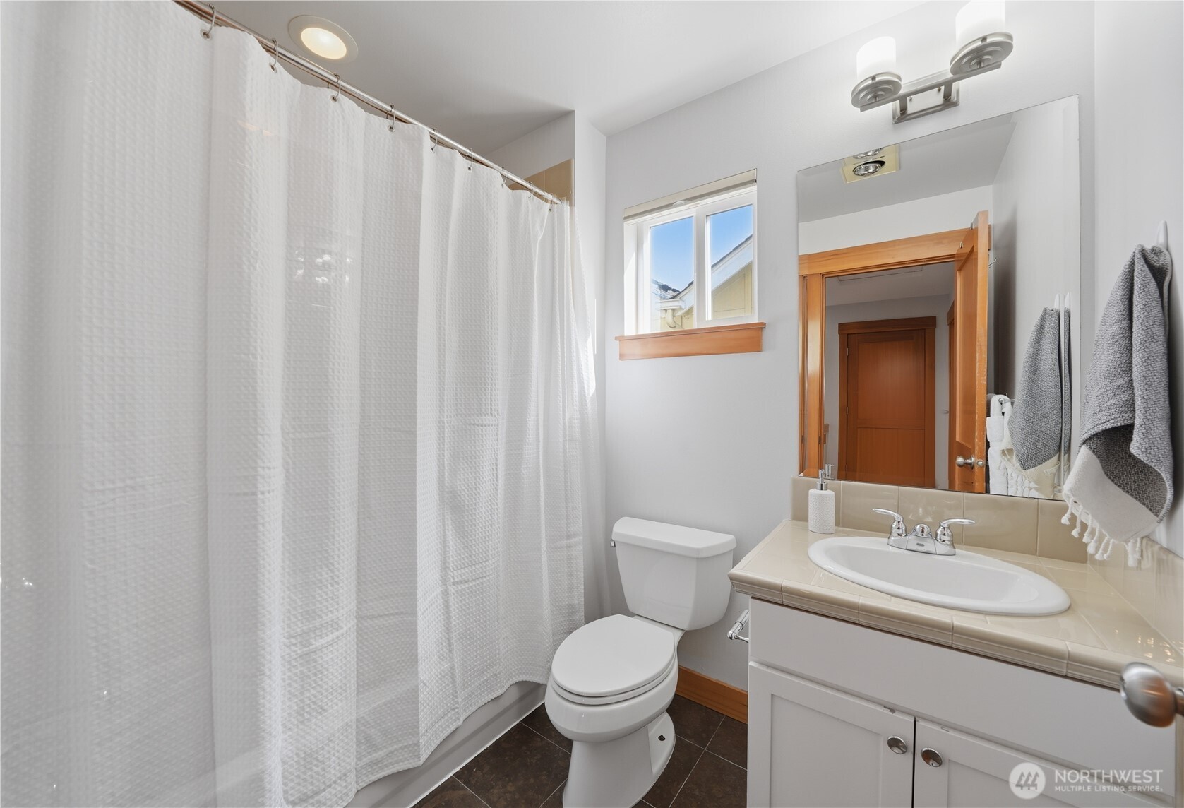 4037 7th Avenue Northeast, Unit A Seattle, WA 98105 - Photo 27 of 35 a bathroom with a granite countertop sink toilet and mirror