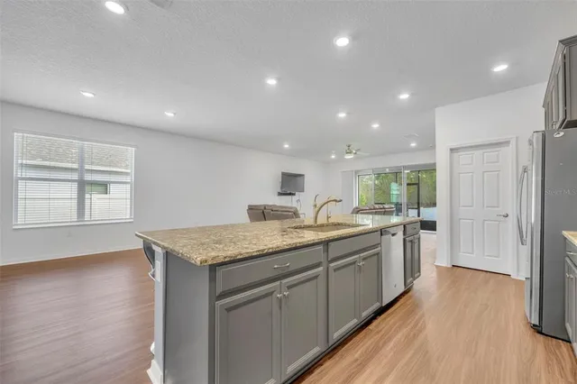 a kitchen with sink attached with living room