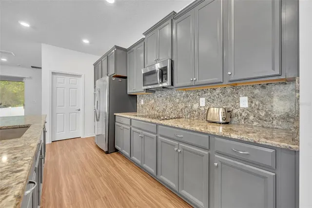 a kitchen with stainless steel appliances granite countertop a sink stove and refrigerator