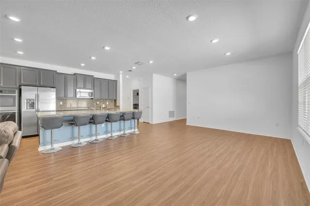 an open kitchen with kitchen island wooden floors and center island