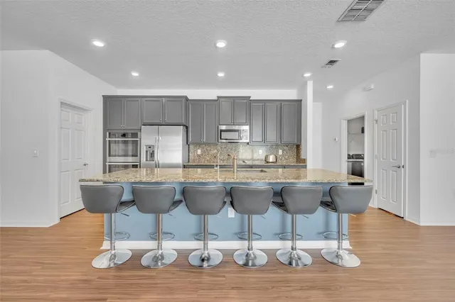 a view of a dining room with furniture wooden floor and kitchen view