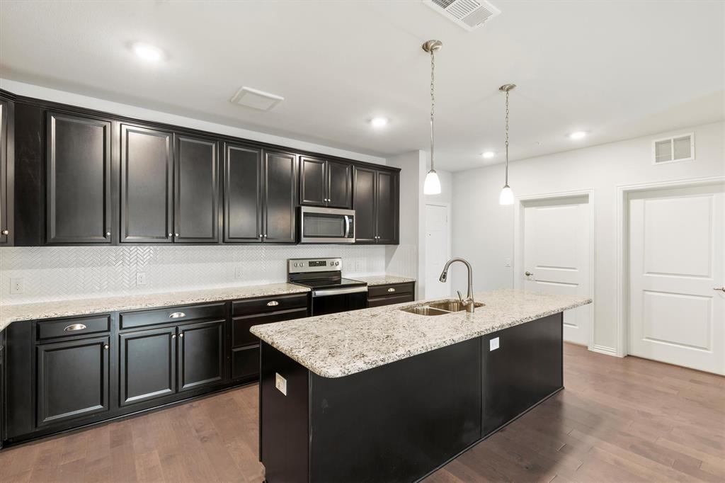 651 Watters Road, Unit 7202 Allen, TX 75013 - Photo 9 of 33 a kitchen with a stove sink and cabinets