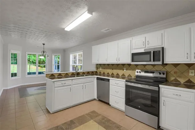 a kitchen with stainless steel appliances granite countertop a stove sink and microwave