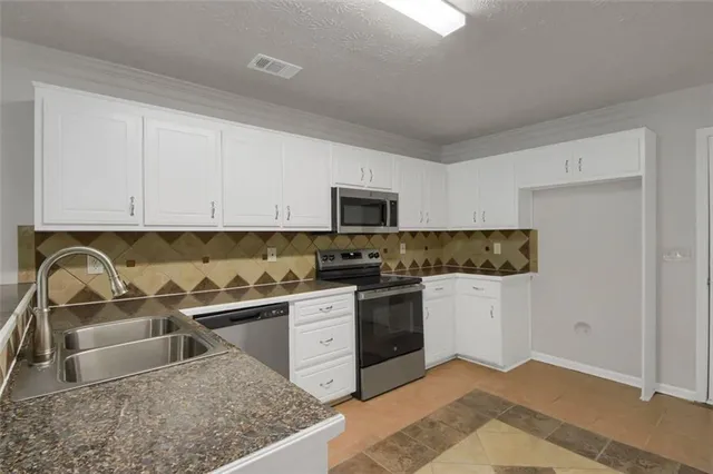 a kitchen with stainless steel appliances granite countertop a sink stove and microwave