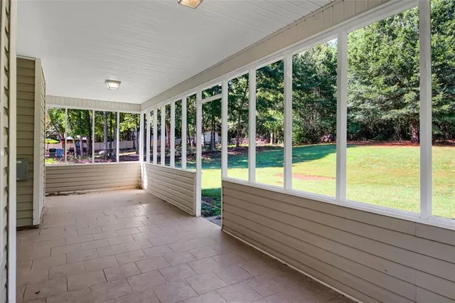a view of an empty room with wooden floor and a yard