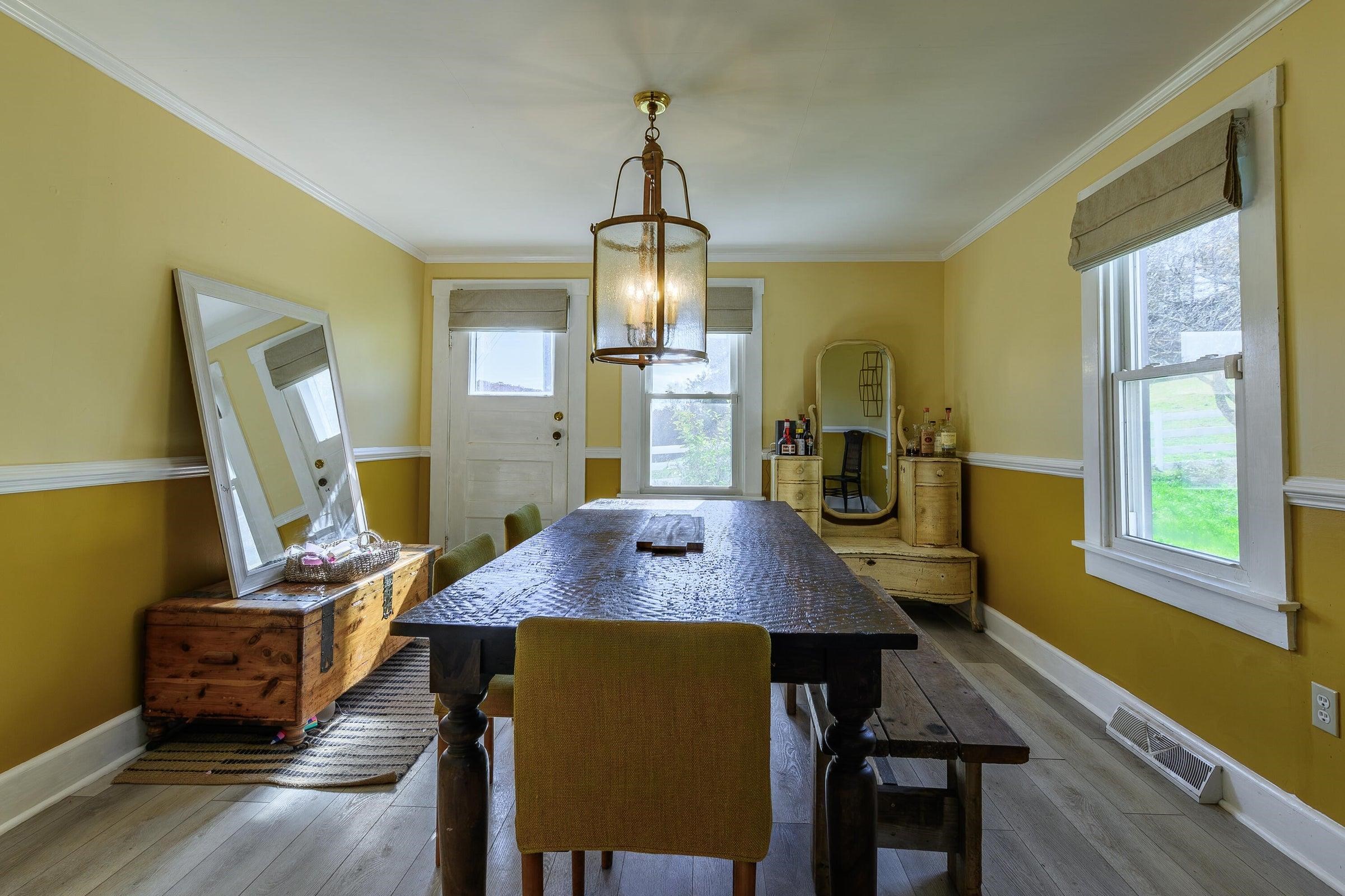 75 Margarets Lane Lexington, VA 24450 - Photo 26 of 55 a dining room with wooden floor a chandelier a wooden table and chairs