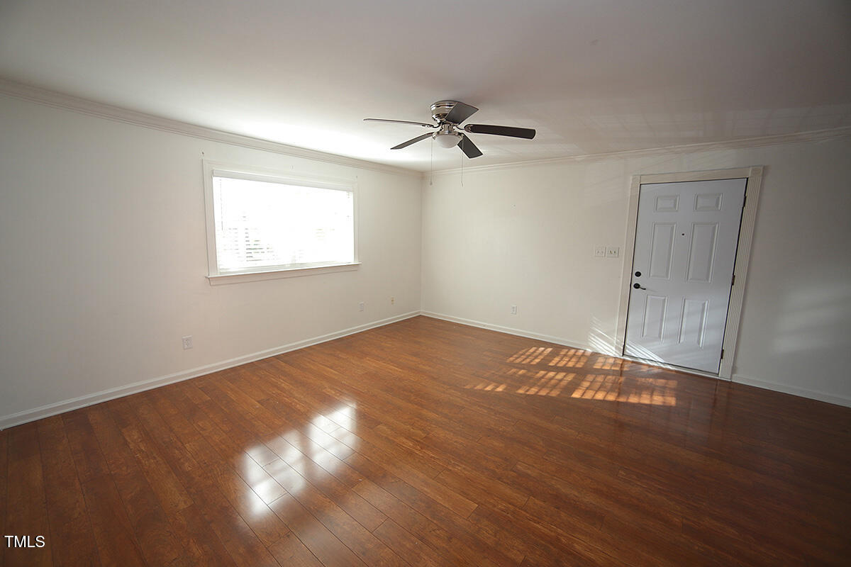 5804 Falls Of Neuse Road, Unit D Raleigh, NC 27609 - Photo 3 of 18 a view of empty room with wooden floor and fan