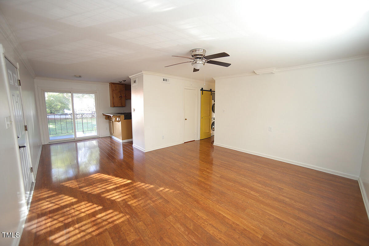 5804 Falls Of Neuse Road, Unit D Raleigh, NC 27609 - Photo 4 of 18 a view of empty room with wooden floor and fan