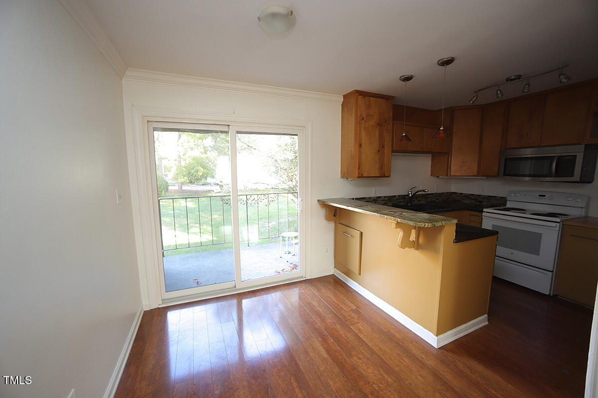 5804 Falls Of Neuse Road, Unit D Raleigh, NC 27609 - Photo 5 of 18 a kitchen with wooden floors and a stove