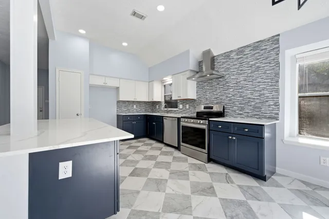 a kitchen with stainless steel appliances granite countertop a stove sink and cabinets