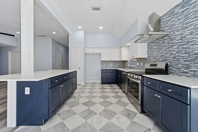 a large kitchen with stainless steel appliances granite countertop a stove sink and cabinets