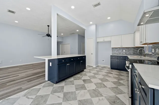 a large kitchen with stainless steel appliances a stove a sink and a refrigerator