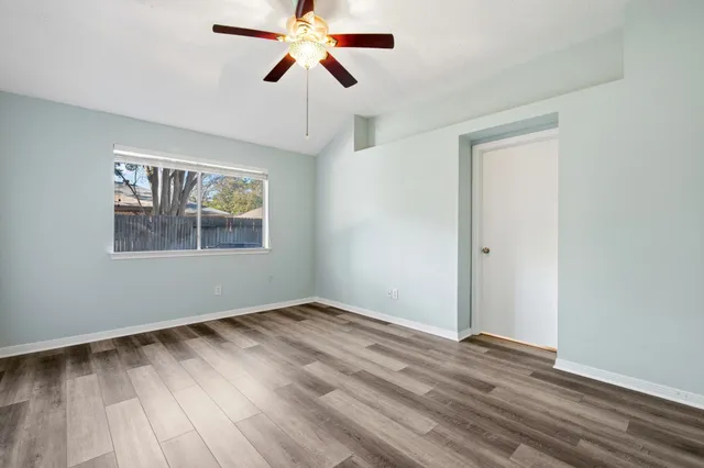 a view of empty room with wooden floor