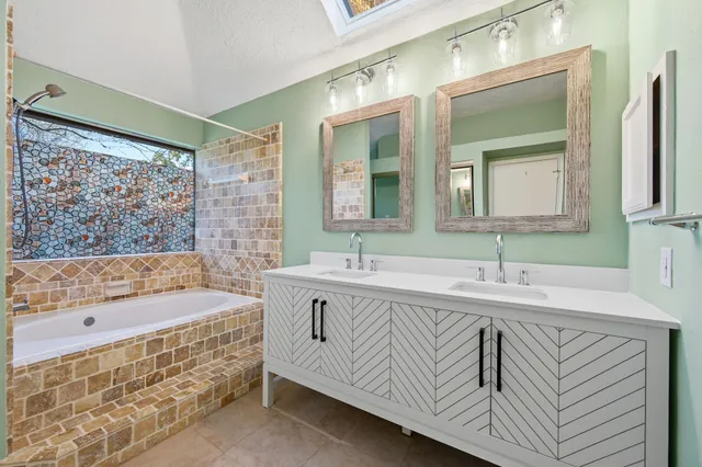 a bathroom with a tub a sink and mirror