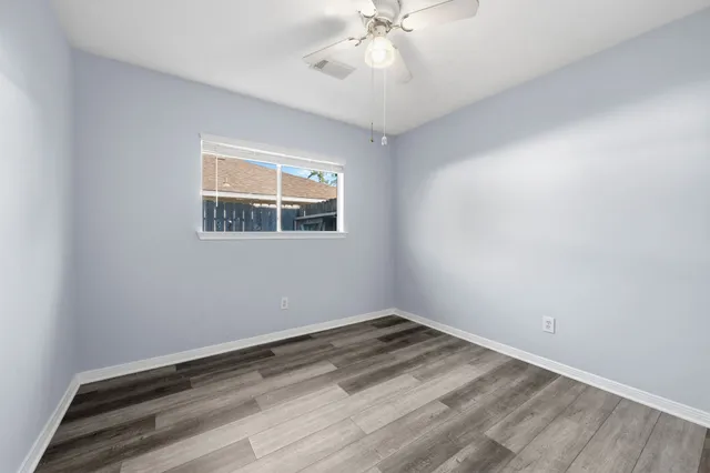 wooden floor in an empty room with a window