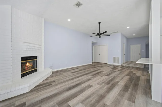 a view of empty room with a fireplace and wooden floor