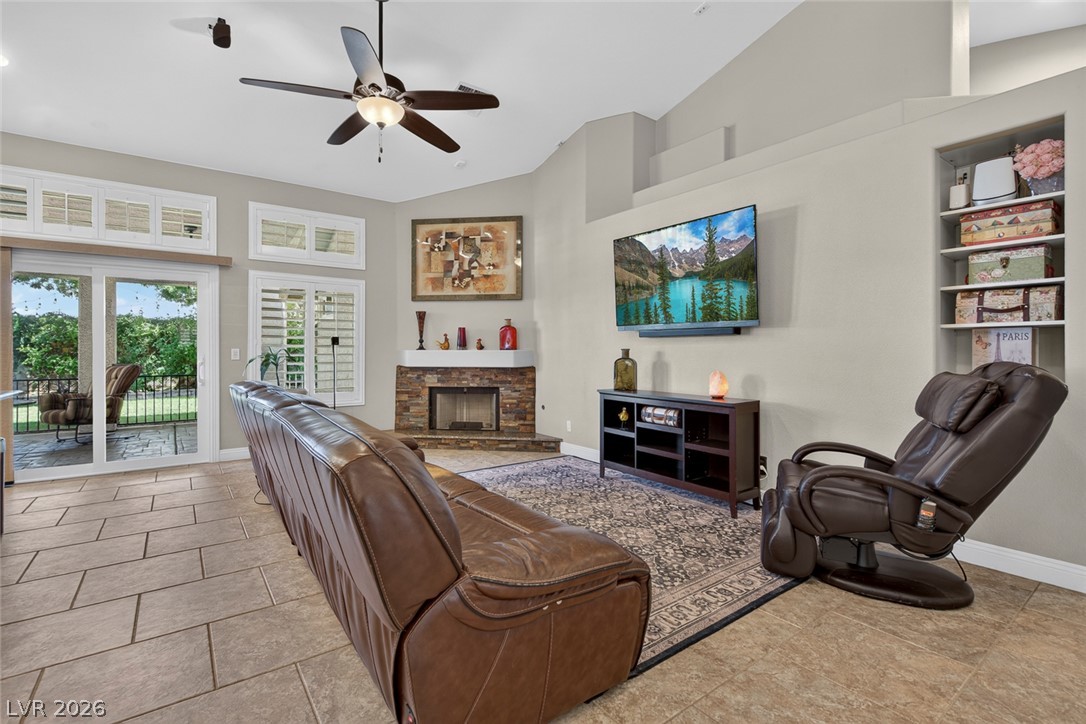 818 Manor Shores Road Henderson, NV 89002 - Photo 10 of 35 Natural light floods this inviting living space, complete with a cozy corner fireplace and seamless outdoor access.