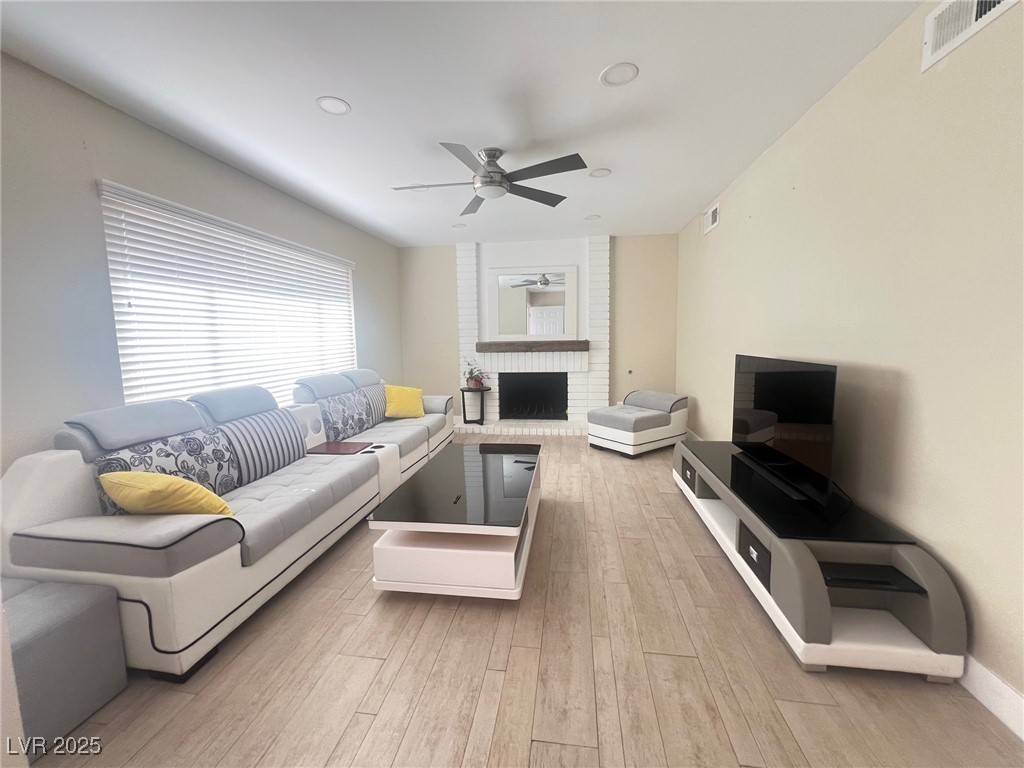 4194 Greenpoint Street Las Vegas, NV 89147 - Photo 3 of 25 Living area featuring a brick fireplace, light wood-style flooring, recessed lighting, and a ceiling fan
