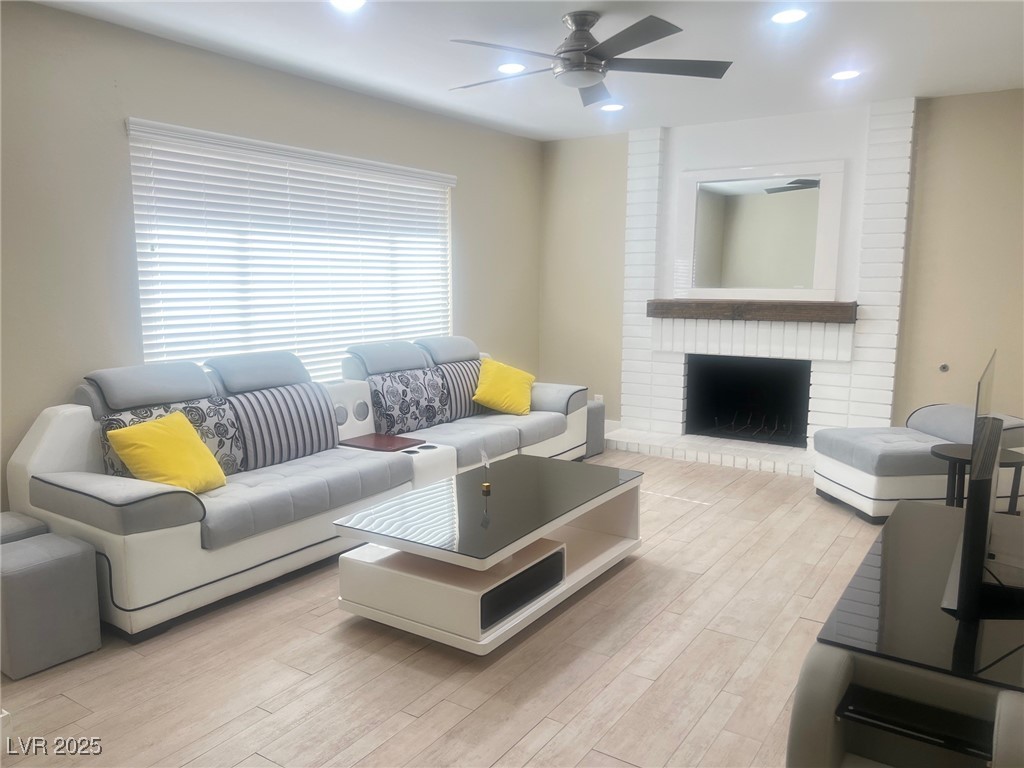 4194 Greenpoint Street Las Vegas, NV 89147 - Photo 4 of 25 Living area featuring light wood-style flooring, recessed lighting, a fireplace, and ceiling fan