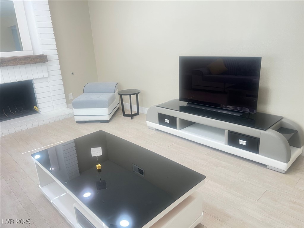 4194 Greenpoint Street Las Vegas, NV 89147 - Photo 5 of 25 Living area featuring light wood-style floors and a fireplace