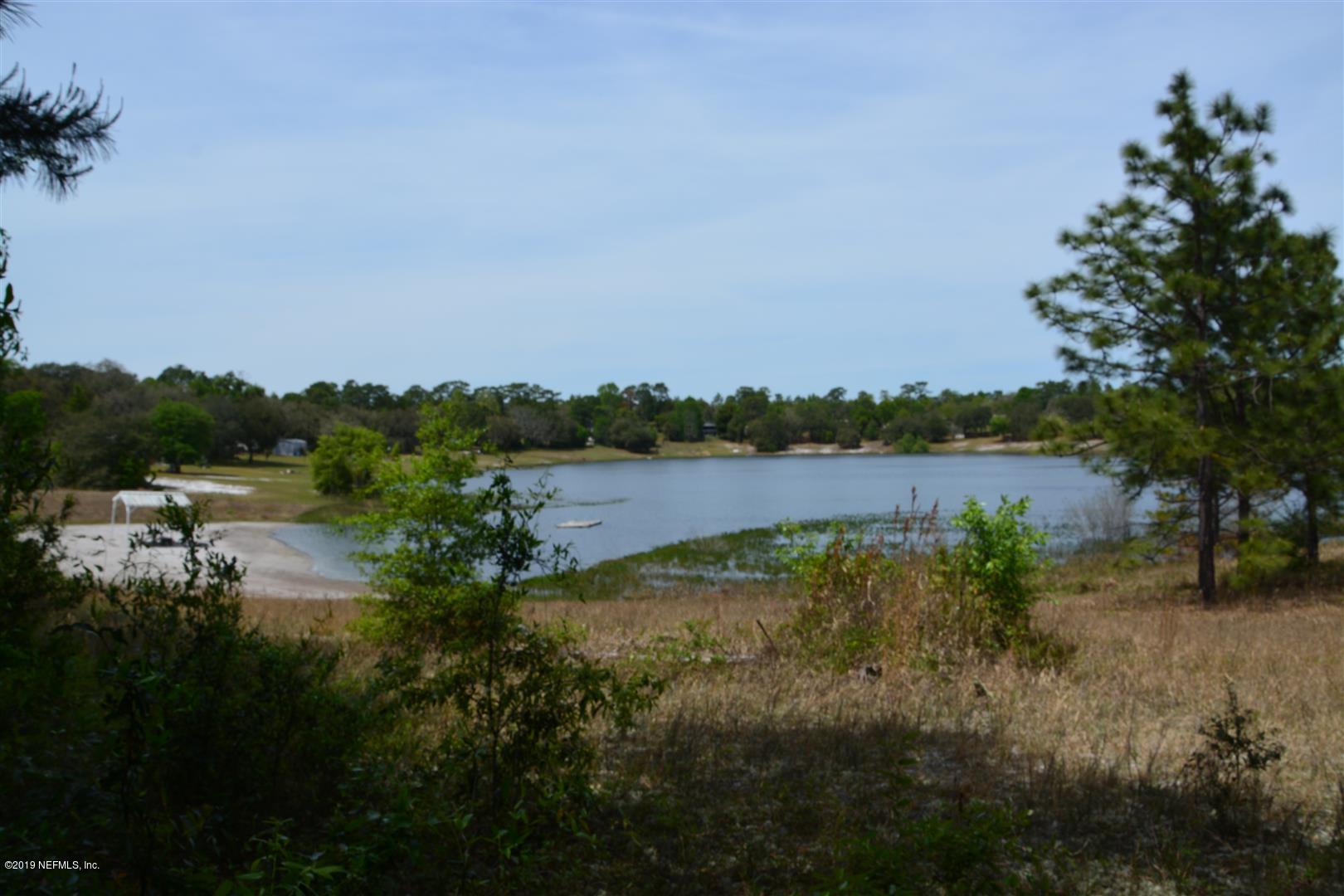 6924 Deer Springs Road Keystone Heights, FL 32656 - Photo 4 of 8 a view of a lake with houses in the back