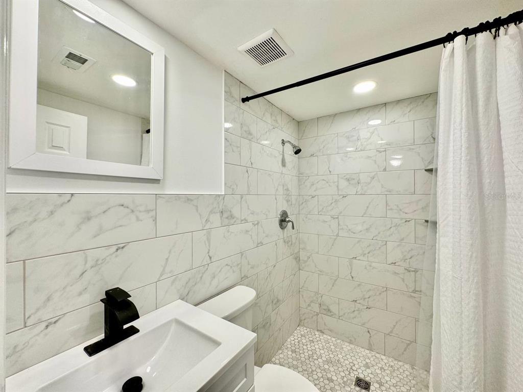 4282 Rudder Way New Port Richey, FL 34652 - Photo 31 of 34 a bathroom with a sink shower and a mirror