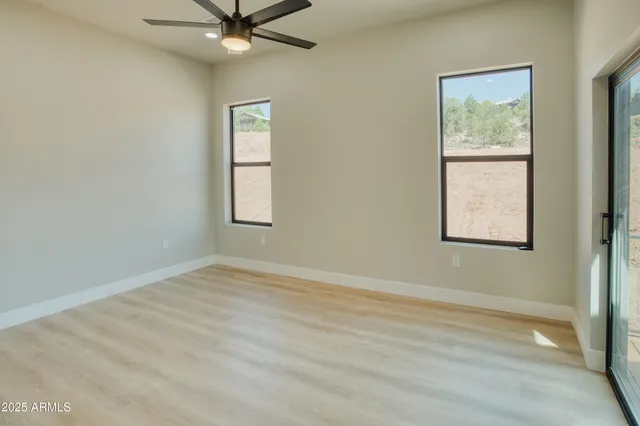 an empty room with windows and fan