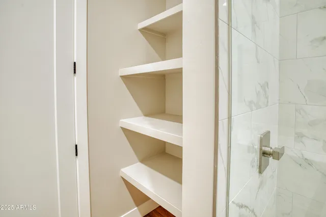 a bathroom with a granite countertop sink a mirror and shower