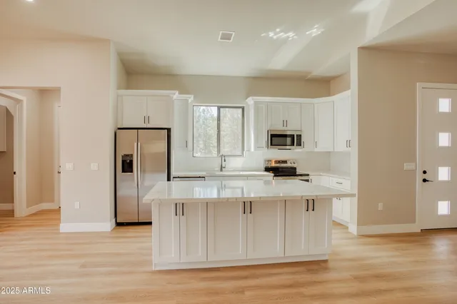a kitchen with stainless steel appliances granite countertop a stove a sink and a refrigerator